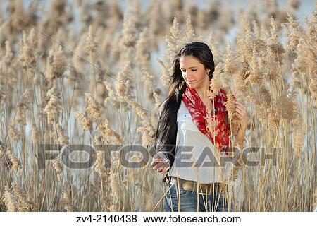 Close-up of a good looking young woman in the reeds on a sunny day in early spring. View Large Photo Image Stock Photo - Close-up of a good looking young woman in the reeds on a sunny day in early spring.. Fotosearch