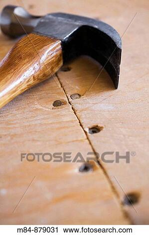 Stock Image - Close-up of a hammer on a plywood floor, Studio Composition, Laval, Quebec, Canada. Fotosearch