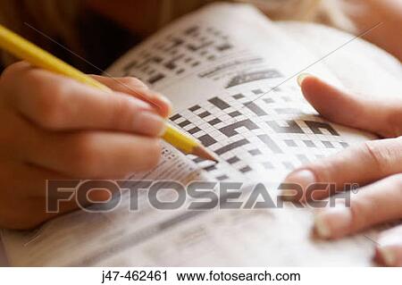 Close-up of a hand holding a pencil doing a crossword View Large Photo Image Stock Image - Close-up of a hand holding a pencil doing a crossword. Fotosearch