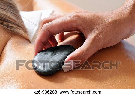 Close up of a hand placing hot stone for therapy View Large Photo Image Stock Photo - Close up of a hand placing hot stone for therapy. Fotosearch