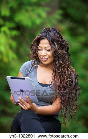 Close up of a happy young woman hand holding an iPad View Large Photo Image Stock Image - Close up of a happy young woman hand holding an iPad. Fotosearch
