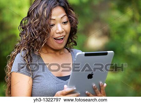 Close up of a happy young woman hand holding an iPad View Large Photo Image Stock Photo - Close up of a happy young woman hand holding an iPad. Fotosearch