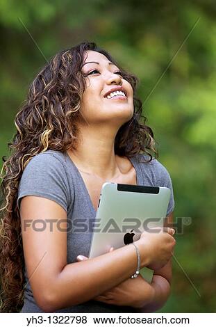 Close up of a happy young woman hand holding an iPad View Large Photo Image Stock Photo - Close up of a happy young woman hand holding an iPad. Fotosearch