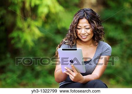 Close up of a happy young woman hand holding an iPad View Large Photo Image Stock Photo - Close up of a happy young woman hand holding an iPad. Fotosearch