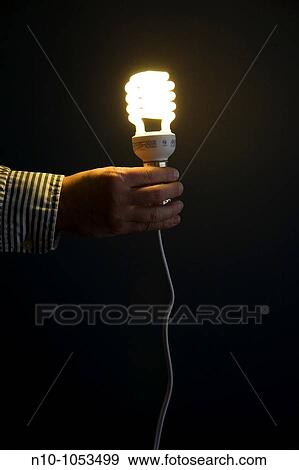 Close-up of a man holding a fluorescent lightbulb View Large Photo Image Stock Photo - Close-up of a man holding a fluorescent lightbulb. Fotosearch
