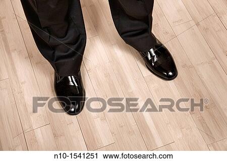 Stock Image - Close-up of a man in a pair of shiny shoes. Fotosearch
