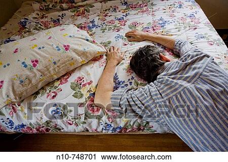 Close-up of a man leaning on a bed. View Large Photo Image Stock Image - Close-up of a man leaning on a bed.. Fotosearch