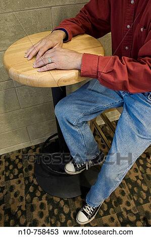 Close-up of a man sitting at a table in a cafe. View Large Photo Image Stock Image - Close-up of a man sitting at a table in a cafe.. Fotosearch