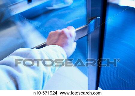 Close-up of a man's hand as he walks through a revolving door View Large Photo Image Picture - Close-up of a man's hand as he walks through a revolving door. Fotosearch