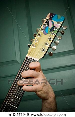Close-up of a man's hand fingering the strings on his guitar View Large Photo Image Stock Photo - Close-up of a man's hand fingering the strings on his guitar. Fotosearch
