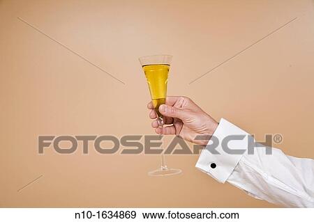 Close-up of a man's hand with a glass of champagne View Large Photo Image Stock Photo - Close-up of a man's hand with a glass of champagne. Fotosearch