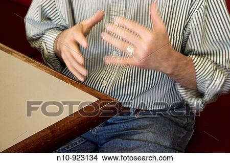 Close-up of a man's hands as he sits at a table View Large Photo Image Picture - Close-up of a man's hands as he sits at a table. Fotosearch