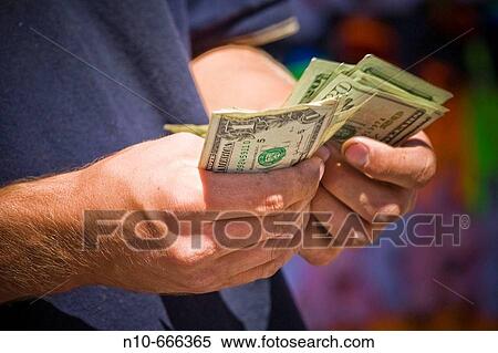Close-up of a man's hands holding money. View Large Photo Image Stock Photography - Close-up of a man's hands holding money.. Fotosearch