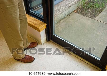 Close-up of a man's legs and feet standing next to a door. View Large Photo Image Stock Photo - Close-up of a man's legs and feet standing next to a door.. Fotosearch