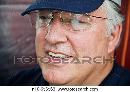 Close-up of a middl-age man wearing glasses and a hat. View Large Photo Image Stock Image - Close-up of a middl-age man wearing glasses and a hat.. Fotosearch