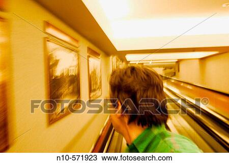 Close-up of a middle aged man, wearing glasses, riding on a moving walkway View Large Photo Image Stock Image - Close-up of a middle aged man, wearing glasses, riding on a moving walkway. Fotosearch