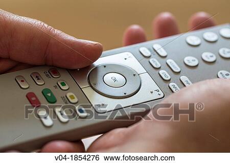 Close up of a person using a remote control View Large Photo Image Stock Photograph - Close up of a person using a remote control. Fotosearch