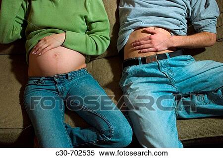 Close-up of a pregnant woman's belly and a man's flat stomach View Large Photo Image Stock Photography - Close-up of a pregnant woman's belly and a man's flat stomach. Fotosearch