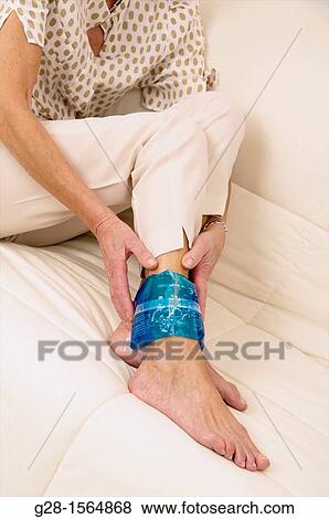 Close up of a Senior woman applying a cold or hot gel compress on her ankle to soothe pain View Large Photo Image Stock Photo - Close up of a Senior woman applying a cold or hot gel compress on her ankle to soothe pain. Fotosearch