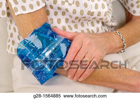 Close up of a Senior woman applying a hot or cold gel compress to soothe elbow pain View Large Photo Image Stock Photography - Close up of a Senior woman applying a hot or cold gel compress to soothe elbow pain. Fotosearch