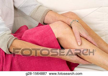 Close up of a Senior woman holding her painful thigh on her sofa View Large Photo Image Stock Photo - Close up of a Senior woman holding her painful thigh on her sofa. Fotosearch