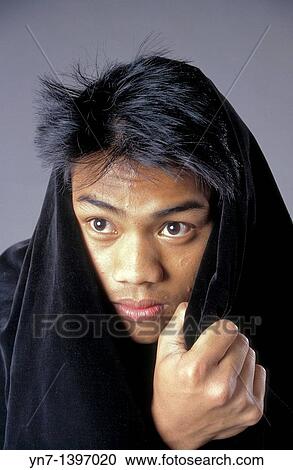 Close up of a teenage boy in a black hood acting rather dramatically View Large Photo Image Stock Image - Close up of a teenage boy in a black hood acting rather dramatically. Fotosearch