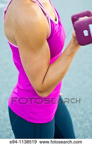 Close up of a thirty year old woman's flexed bi-cep pumping a dumbbell. View Large Photo Image Stock Photo - Close up of a thirty year old woman's flexed bi-cep pumping a dumbbell.. Fotosearch