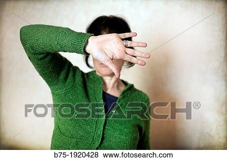 Close-up of a woman covering her face View Large Photo Image Stock Photo - Close-up of a woman covering her face. Fotosearch