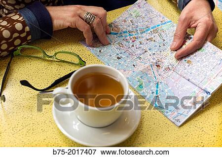 Close-up of a woman drinking a tea in a bar and looking at a map of the city of Paris, France, Europe View Large Photo Image Stock Photo - Close-up of a woman drinking a tea in a bar and looking at a map of the city of Paris, France, Europe. Fotosearch