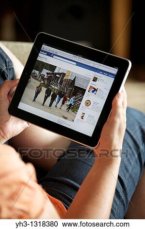 Close up of a woman hand holding an iPad checking her Facebook page View Large Photo Image Stock Image - Close up of a woman hand holding an iPad checking her Facebook page. Fotosearch