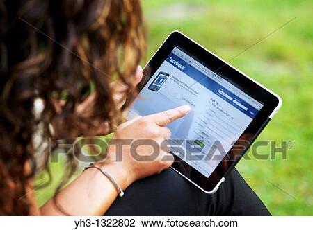 Close up of a woman hand holding an iPad checking her Facebook page View Large Photo Image Stock Image - Close up of a woman hand holding an iPad checking her Facebook page. Fotosearch