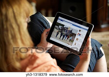 Close up of a woman hand holding an iPad checking her Facebook page View Large Photo Image Stock Photo - Close up of a woman hand holding an iPad checking her Facebook page. Fotosearch