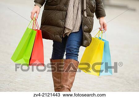 Close-up of a woman holding shopping bags in her hand. View Large Photo Image Stock Image - Close-up of a woman holding shopping bags in her hand.. Fotosearch