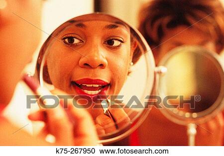 Close-up of a woman putting on lipstick View Large Photo Image Stock Image - Close-up of a woman putting on lipstick. Fotosearch