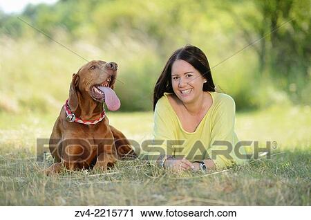 Close-up of a Woman with a Hungarian or Magyar Vizsla (Vizsla) on a meadow in spring. View Large Photo Image Stock Image - Close-up of a Woman with a Hungarian or Magyar Vizsla (Vizsla) on a meadow in spring.. Fotosearch