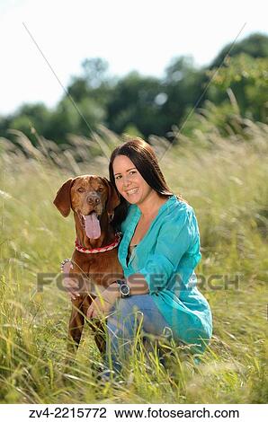 Close-up of a Woman with a Hungarian or Magyar Vizsla (Vizsla) on a meadow in spring. View Large Photo Image Stock Image - Close-up of a Woman with a Hungarian or Magyar Vizsla (Vizsla) on a meadow in spring.. Fotosearch