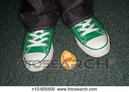 Close-up of a woman's green sneakers next to a small yellow rubber duck. View Large Photo Image Stock Photo - Close-up of a woman's green sneakers next to a small yellow rubber duck.. Fotosearch
