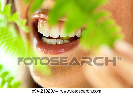 Close up of a woman's mouth and teeth framed by fern leaves. View Large Photo Image Picture - Close up of a woman's mouth and teeth framed by fern leaves.. Fotosearch