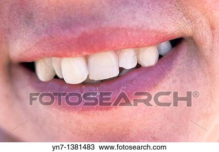 Stock Image - close up of a woman's mouth with an emphasis on her sculptural teeth as she smiles for us. Fotosearch