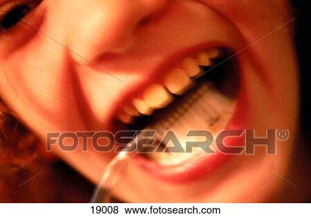 Stock Photo - Close up of a young teenage girl brushing her teeth, slightly blurry. Fotosearch