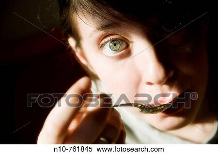 Close-up of a young woman eating a spoonful of applesauce View Large Photo Image Stock Photography - Close-up of a young woman eating a spoonful of applesauce. Fotosearch