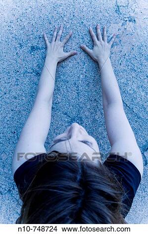 Picture - Close-up of a young woman facing a wall.. Fotosearch