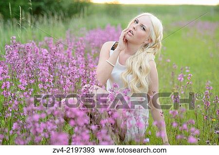 Close-up of a young woman in a flower field at sunset. View Large Photo Image Stock Image - Close-up of a young woman in a flower field at sunset.. Fotosearch