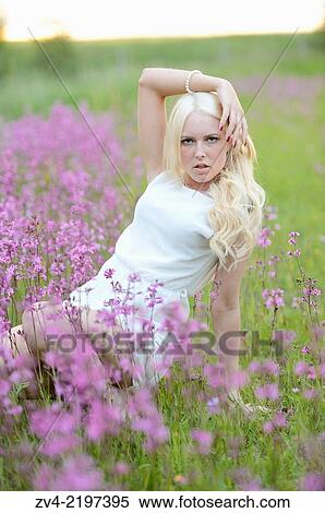 Close-up of a young woman in a flower field at sunset. View Large Photo Image Stock Photography - Close-up of a young woman in a flower field at sunset.. Fotosearch