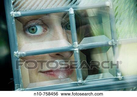 Close-up of a young woman looking out a window. View Large Photo Image Stock Photograph - Close-up of a young woman looking out a window.. Fotosearch