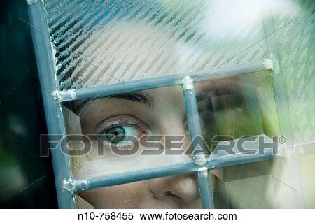 Close-up of a young woman looking out a window. View Large Photo Image Stock Photography - Close-up of a young woman looking out a window.. Fotosearch