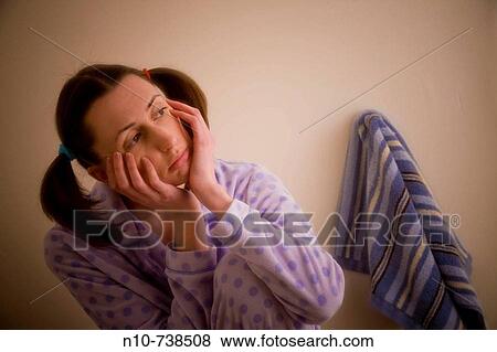 Close-up of a young woman sitting next to a towel in her bathroom. View Large Photo Image Stock Photo - Close-up of a young woman sitting next to a towel in her bathroom.. Fotosearch