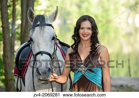Close-up of a young woman standing beside a Quarab horse. View Large Photo Image Stock Image - Close-up of a young woman standing beside a Quarab horse.. Fotosearch