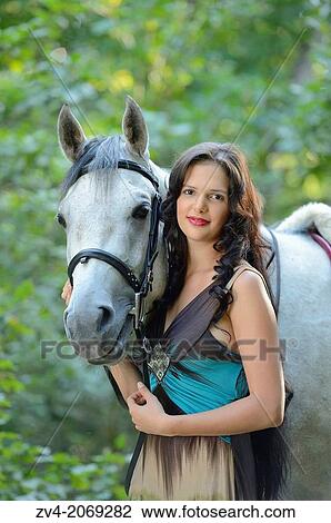 Close-up of a young woman standing beside a Quarab horse. View Large Photo Image Stock Image - Close-up of a young woman standing beside a Quarab horse.. Fotosearch