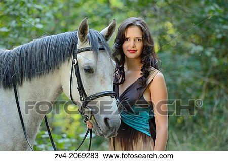 Close-up of a young woman standing beside a Quarab horse. View Large Photo Image Stock Image - Close-up of a young woman standing beside a Quarab horse.. Fotosearch